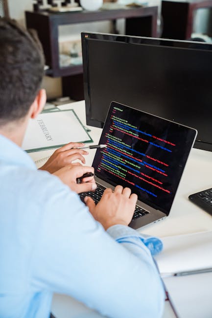 Image of a computer screen displaying a close-up view of colorful lines of programming code in various shades of red, green, blue, yellow, and white. The code appears to be written in JavaScript, with